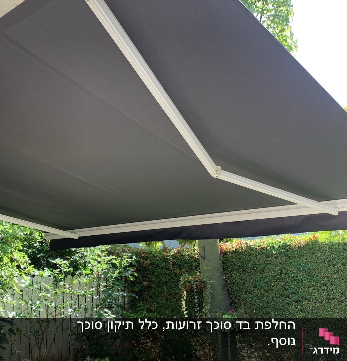 סוכך בד כהה עם מסגרת מתכת לבנה בגינה